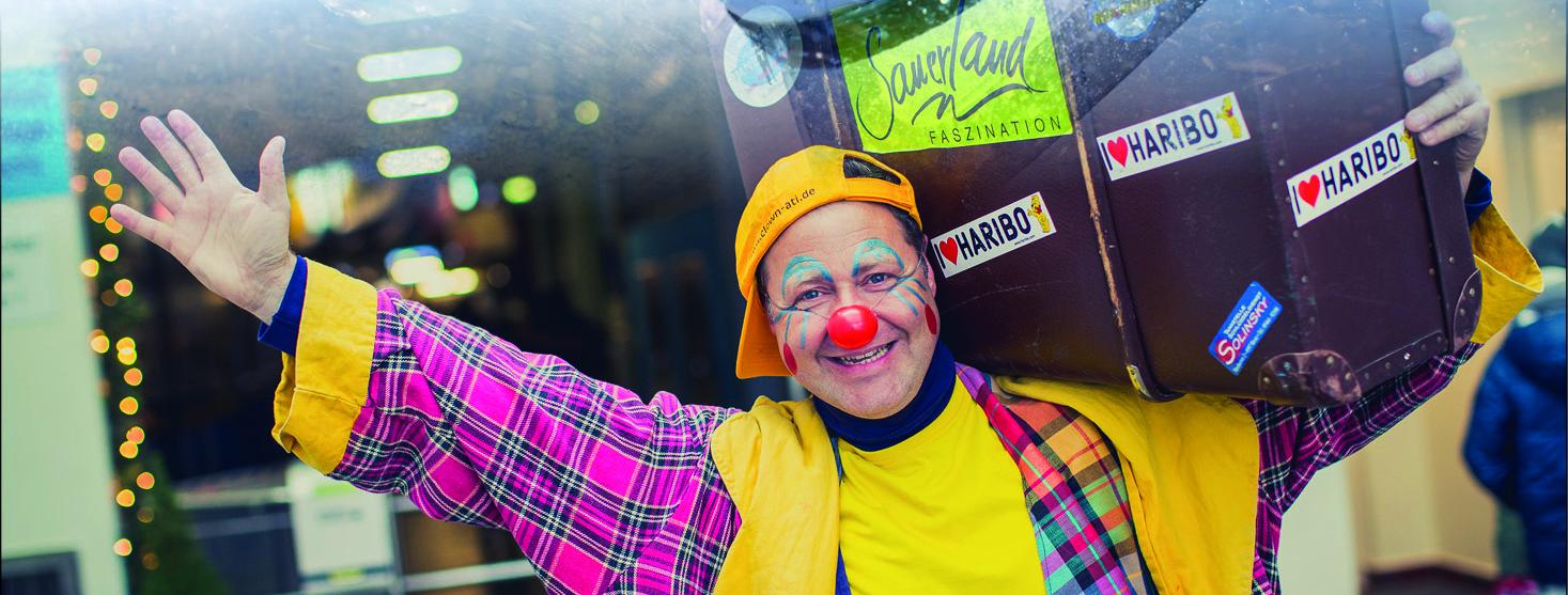 Fröhlicher Clown mit Gepäck
